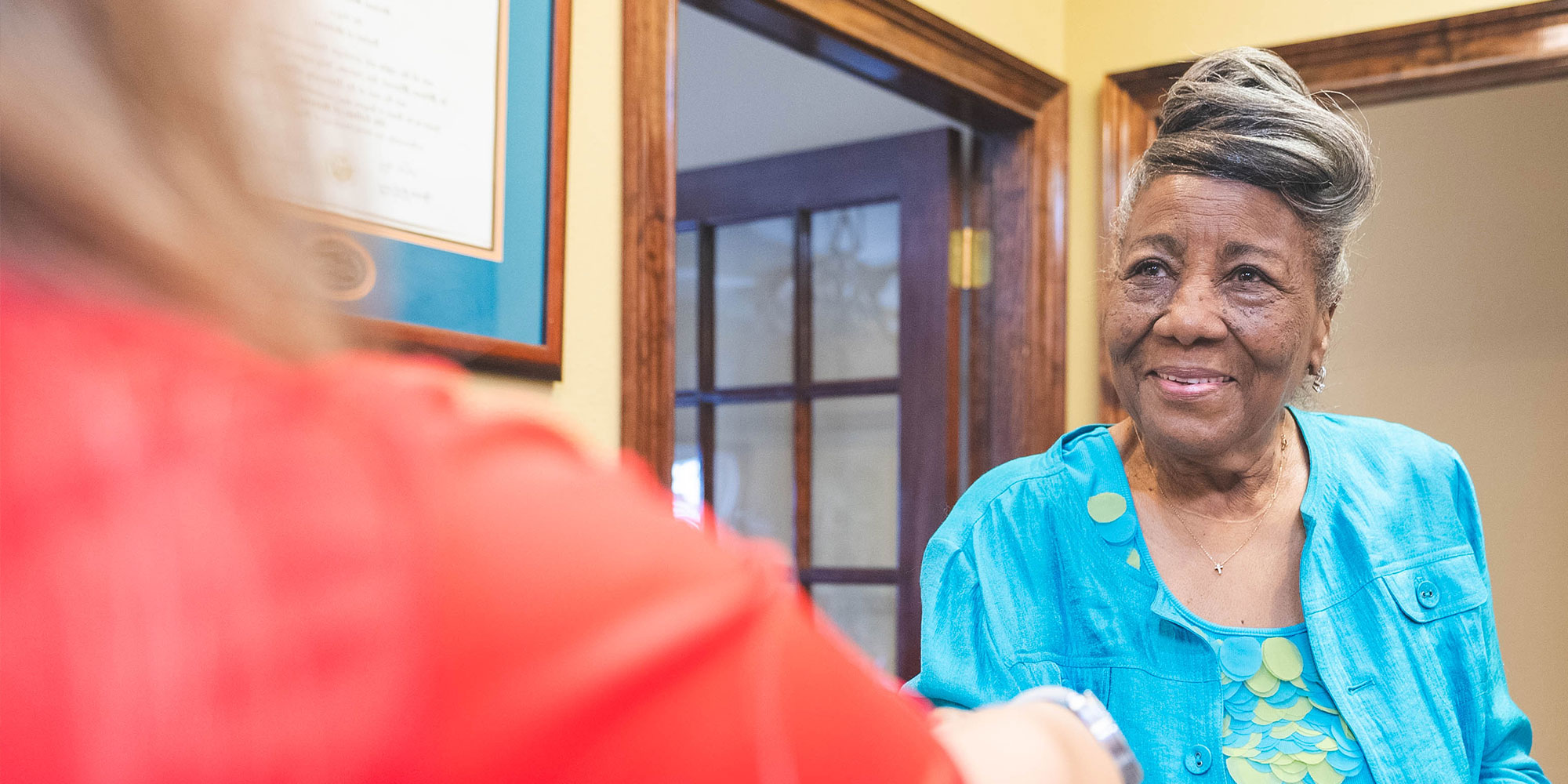 patient being helped at the front desk by the staff member
