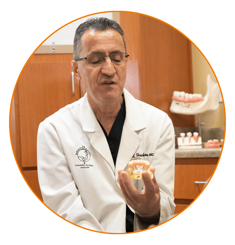 doctor holding out a full dental implant model