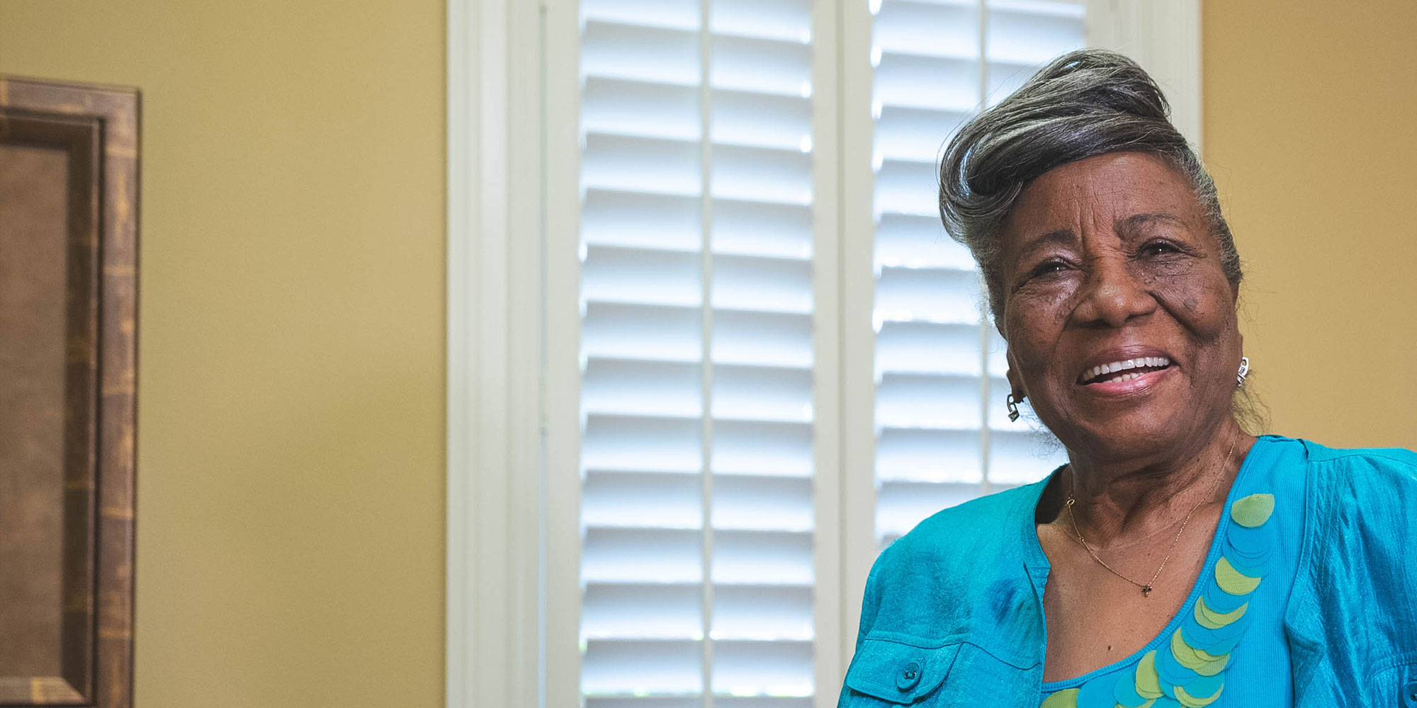 Protrait of dental implant patient smiling brightly within the dental procedure room