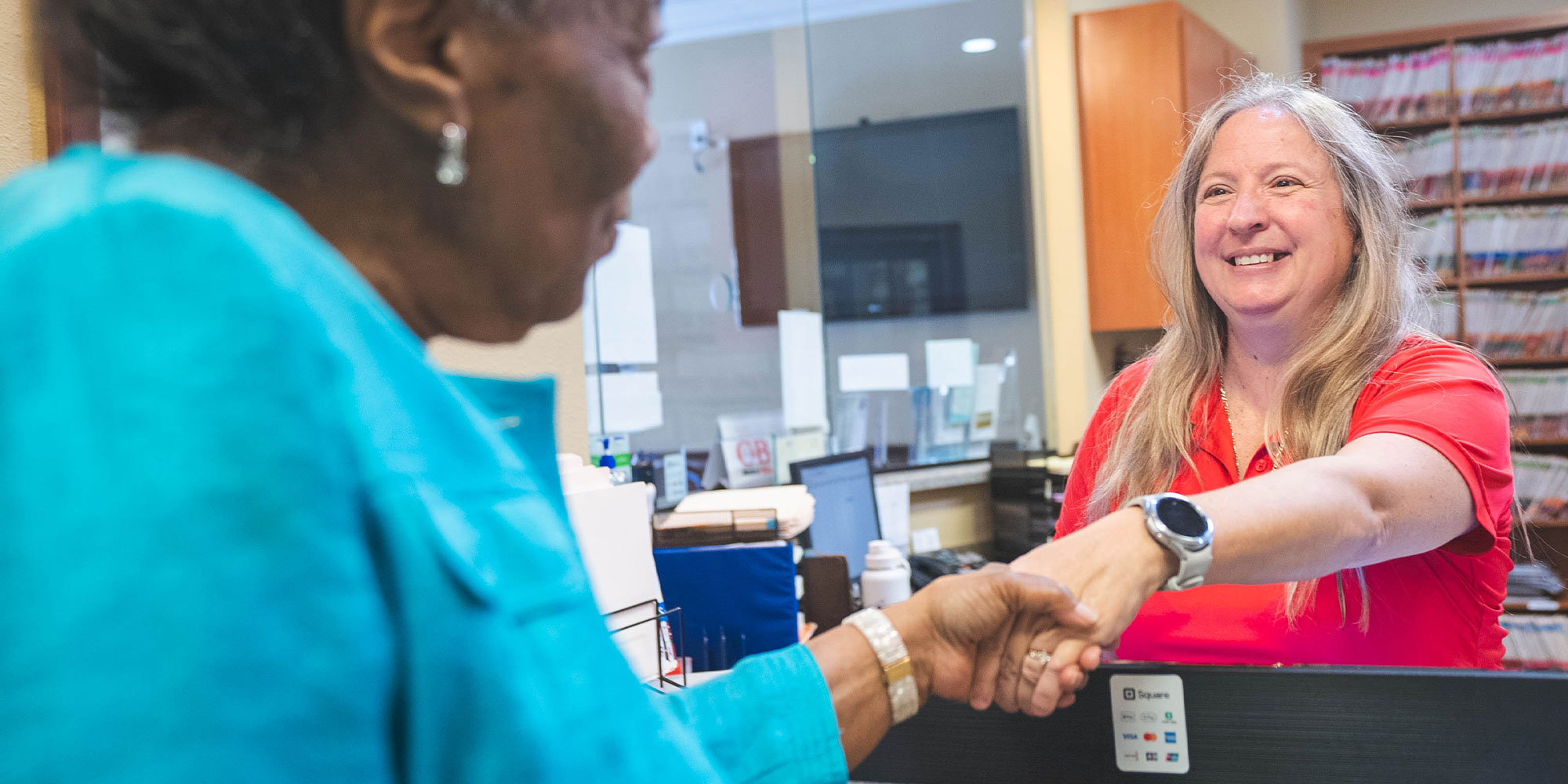 staff member helping patient at the front desk of the dental center